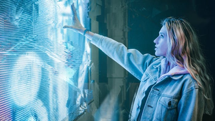 Una ragazza interagisce con l'intelligenza artificiale toccando uno schermo