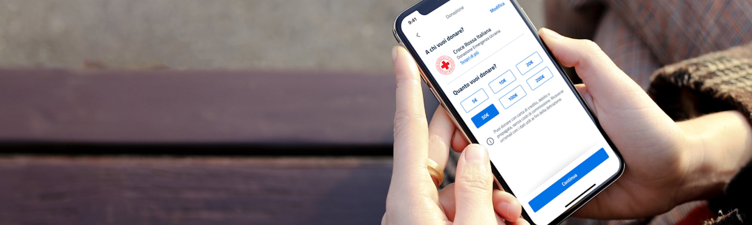 una mano tiene un telefono con app IO